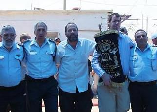 שוטרים ומתיישבים רוקדים יחד בחברון עם ספר התורה
