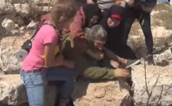 ביזיון: פלסטיניות מכות חייל שאינו יכול להגיב