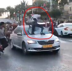 צפו: מפגינים מטפסים על רכב נוסע וחובטים בו