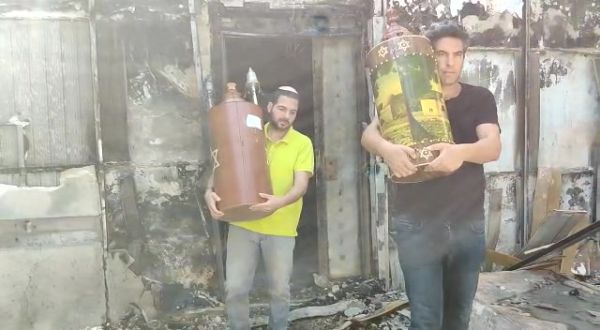 צפו: לאחר הפוגרום- ספרי תורה מוצאים מבי"כ השרוף