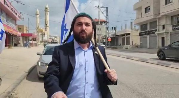 בלי פחד: צבי סוכות צועד עם דגל ישראל בחווארה