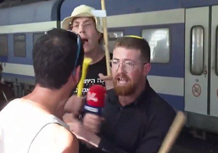 טירוף: עיתונאי ערוץ 14 הותקף באלימות בשידור.צפו