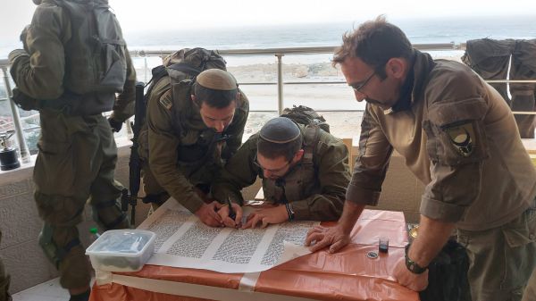 תמונת הניצחון: לוחמים כותבים ספר תורה בעיר עזה