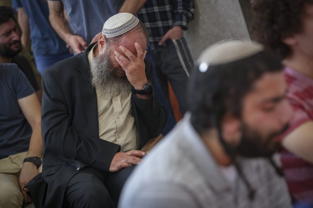 Friends and family mourn Rabbi Miki Mark at a service prior to his funeral at the Otniel yeshiva, of which Rabbi Mark was director. Rabbi Mark was murdered in a terror attack on Friday, when his family’s car came under gunfire from a passing vehicle and overturned near Beit Hagai on Route 60. Rabbi Mark's wife and two of their children were injured in the shooting attack. July 03, 2016. Photo by Hadas Parush/FLASH90 *** Local Caption *** עותניאל פיגוע רב מיקי מרק