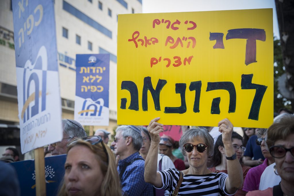 American and Israeli Orthodox and Conservative Jews protest outside the Chief Rabbinate offices in Jerusalem, against the Rabbinate's disqualification of American rabbis' conversions, on July 6, 2016. The protest was held in response to the Israeli Chief Rabbinate's rejection of an American woman's conversion approved by well known American Rabbi Heskel Lookstein, the Yeshuron Community Rabbi in New York and senior Orthodox Rabbi in the United States. Photo by Hadas Parush/Flash90 *** Local Caption *** הפגנה מחאה תנועה מסורתית אורתודוקסים קונסרבטיביים שלטים דב ליפמן הקצנה הרבנות הראשית ישראל אמריקאית גיור הרב יחזקאל לוקשטיין ניו יוקר נישואים ארצות הברית יהדות אמריקה גר