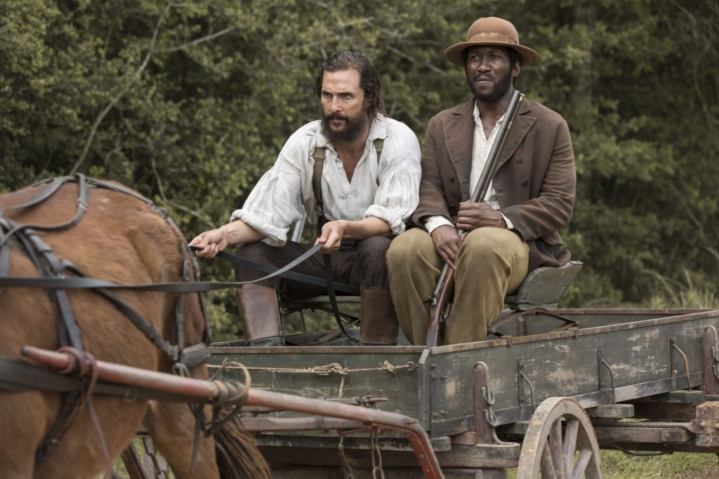 While driving the horse wagon down a country road, Newt (Matthew McConaughey) tries to stop Moses (Mahershala Ali)