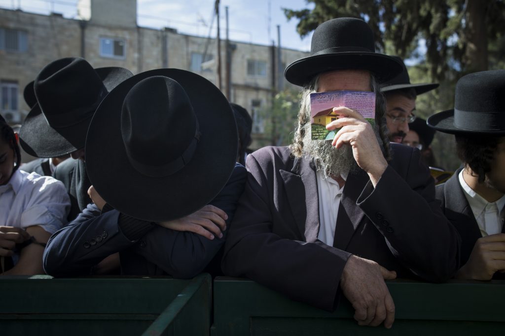 Ultra orthoodx jewish men gather to pray during a demonstration in support of Rabbi Eliezer Berland Outside the Magistrate's court in Jerusalem where Berland is put on trial for sexual assualt charges, on November 22, 2016. Rabbi Berland left Israel to South Africa while he was suspected and under investigation for sexual assualt on women in his community. He was jailed in South Africa and extradited to Israel. Photo by Yonatan Sindel/ Flash90 *** Local Caption *** תפילה בית משפט דרום אפריקה הרב אליעזר ברלנד רב כלא אונס