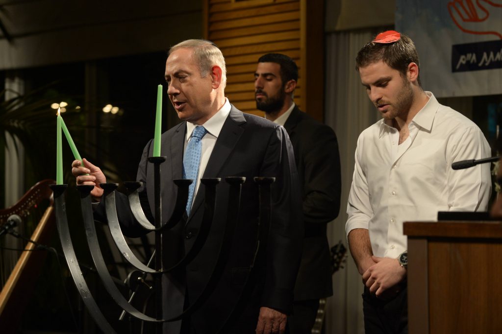 Israeli prime minister Benjamin Netanyahu lights the Chanucka candles on the first night of the Jewish holiday of Hanukkah, at Ronit's farm, outside Tel Aviv on December 24, 2016. Photo by Amos Ben Gershom/GPO *** Local Caption *** øàù äîîùìä áðéîéï ðúðéäå áéáé çðåëä ðø ðøåú